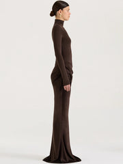 Woman wearing a brown long-sleeve dress against a white background