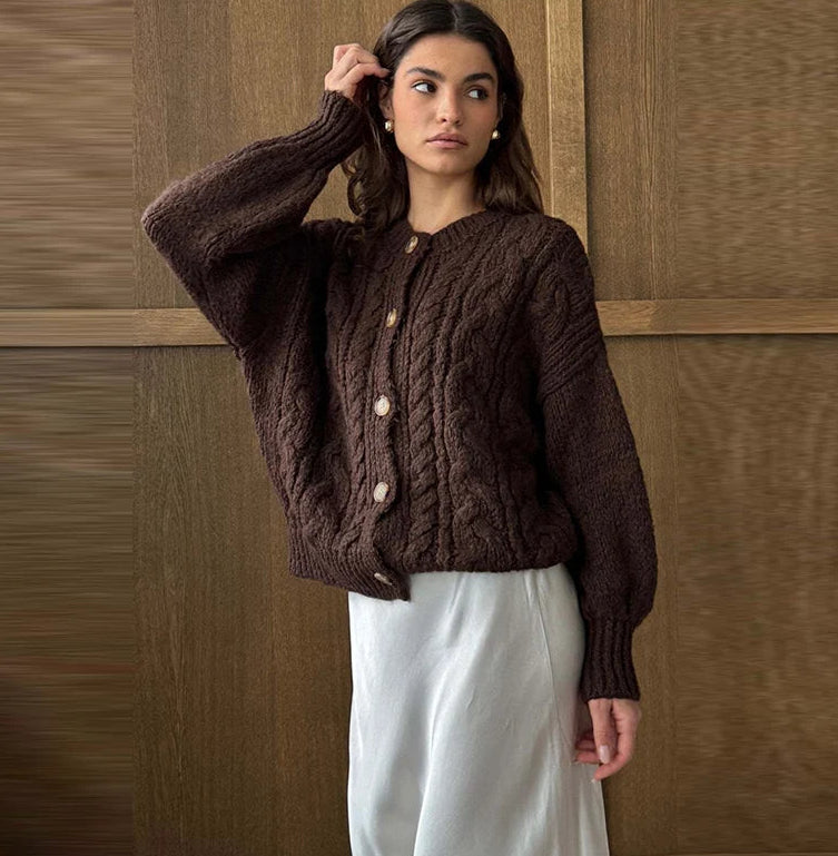 Woman wearing a brown knitted cardigan against a wooden paneled wall