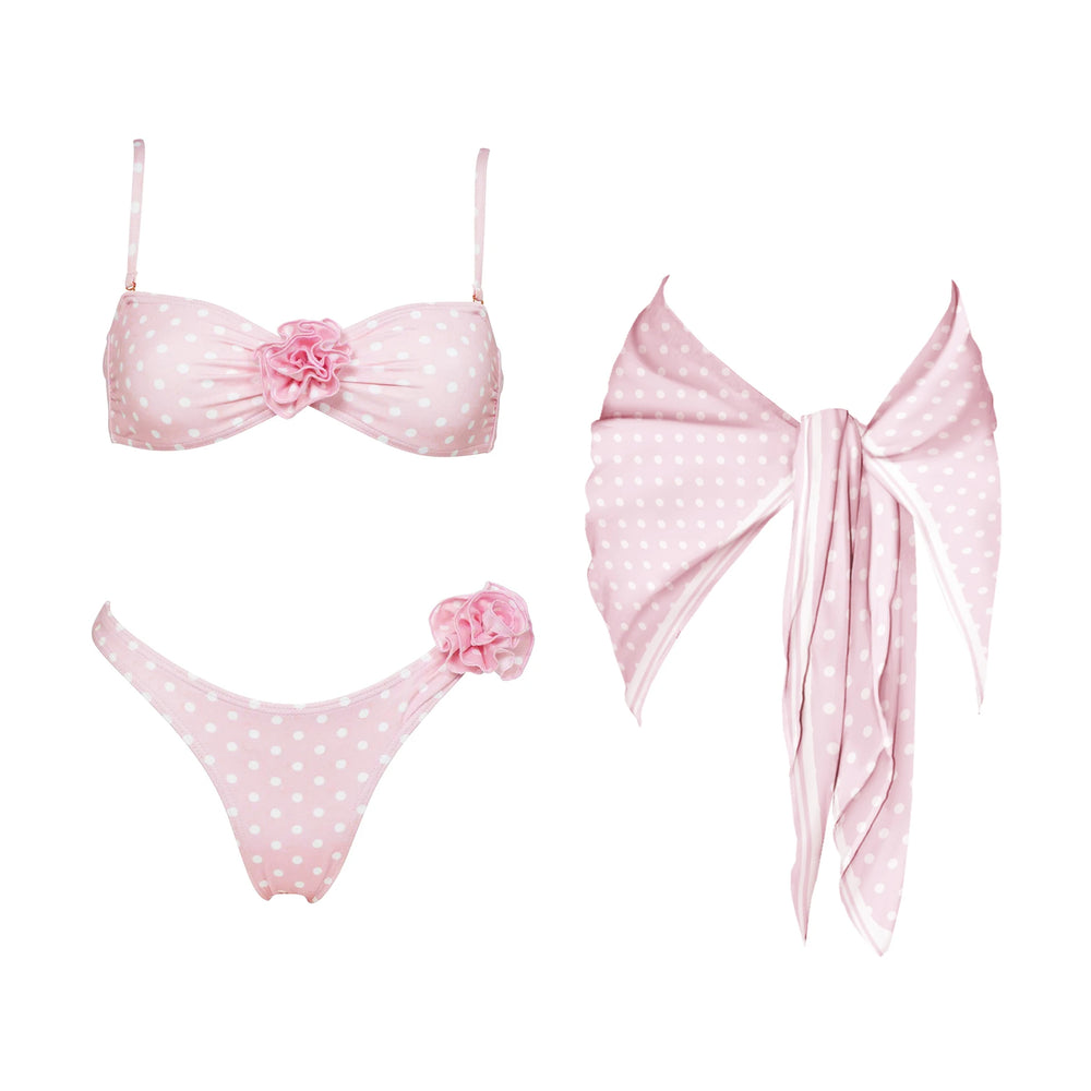 Pink polka dot bikini set with floral accents and matching scarf.
