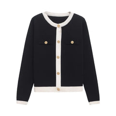 Black cardigan with white trim and gold buttons on a white background