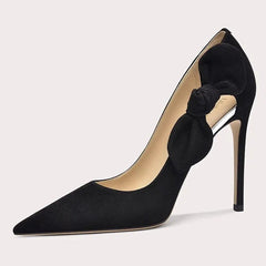 Black high-heeled shoe with a bow on a light gray background