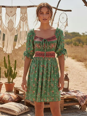 Green floral print mini dress with smocked empire waist and tie-front neckline