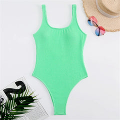Green ribbed high-cut one-piece swimwear laid flat