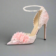 Pink high-heeled shoe with floral design on a light background