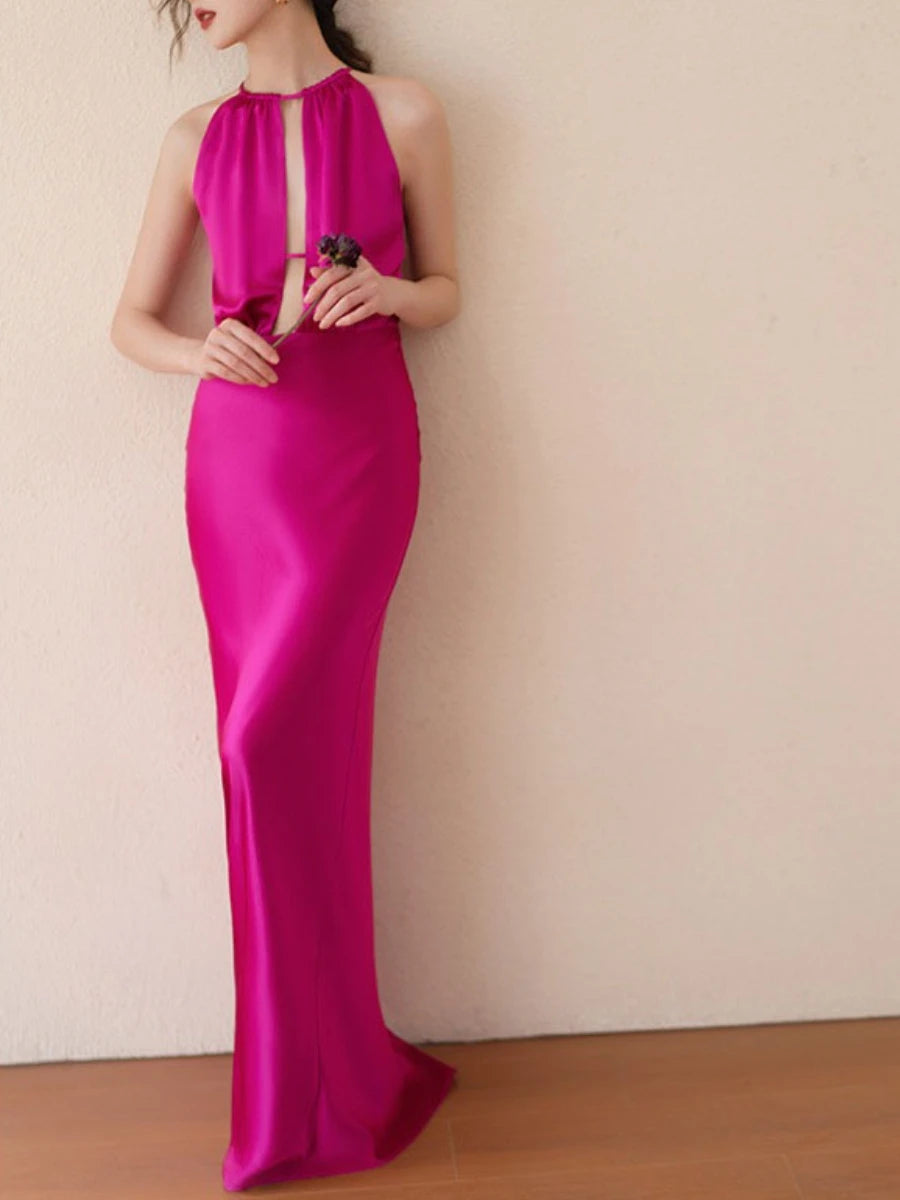 Woman wearing a bright pink evening gown against a plain background