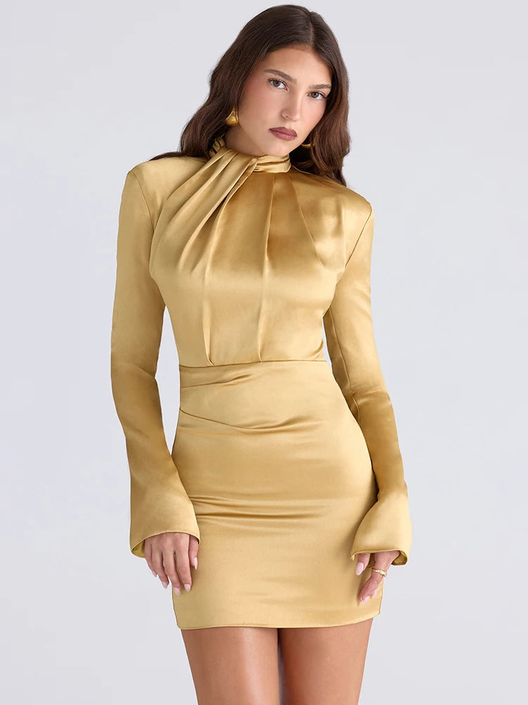 Woman wearing a gold dress with long sleeves on a light gray background