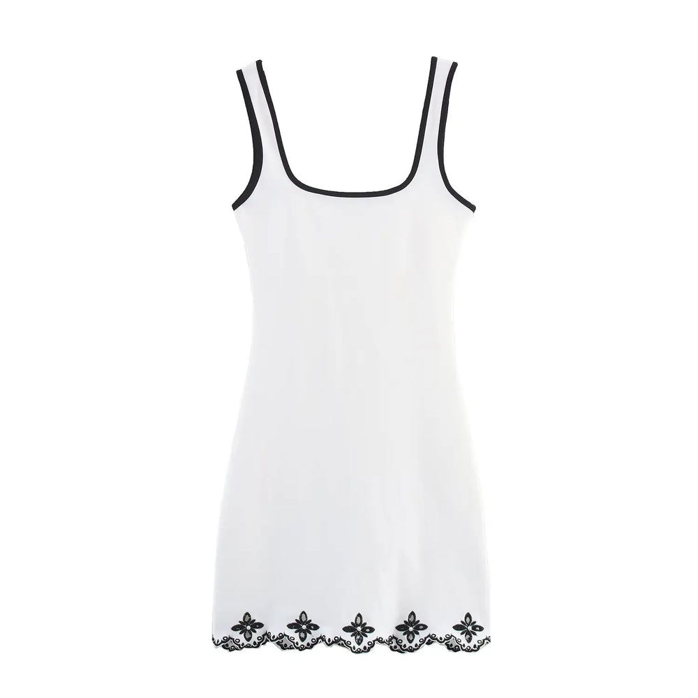 White slip dress with black lace trim on a white background