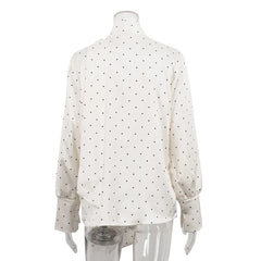 White blouse with black polka dots on a mannequin against a white background