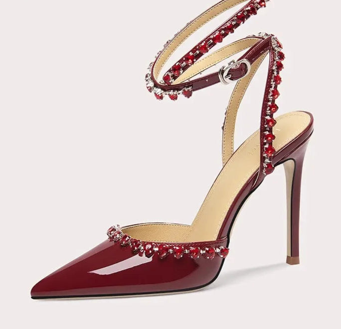 High-heeled shoe with red embellishments on a white background