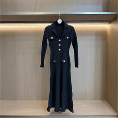 Black coat with white buttons on a hanger against a wooden background