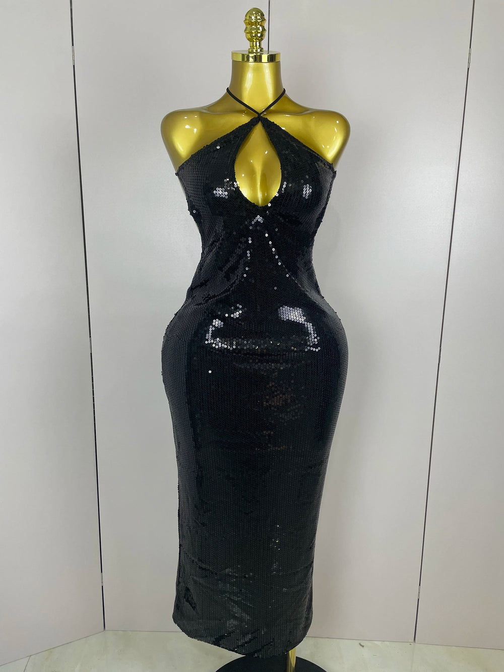 Black sequin dress on a mannequin against a white background