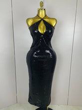Black sequin dress on a mannequin against a white background