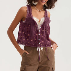 Woman wearing a purple sleeveless top with lace details and brown pants on a white background