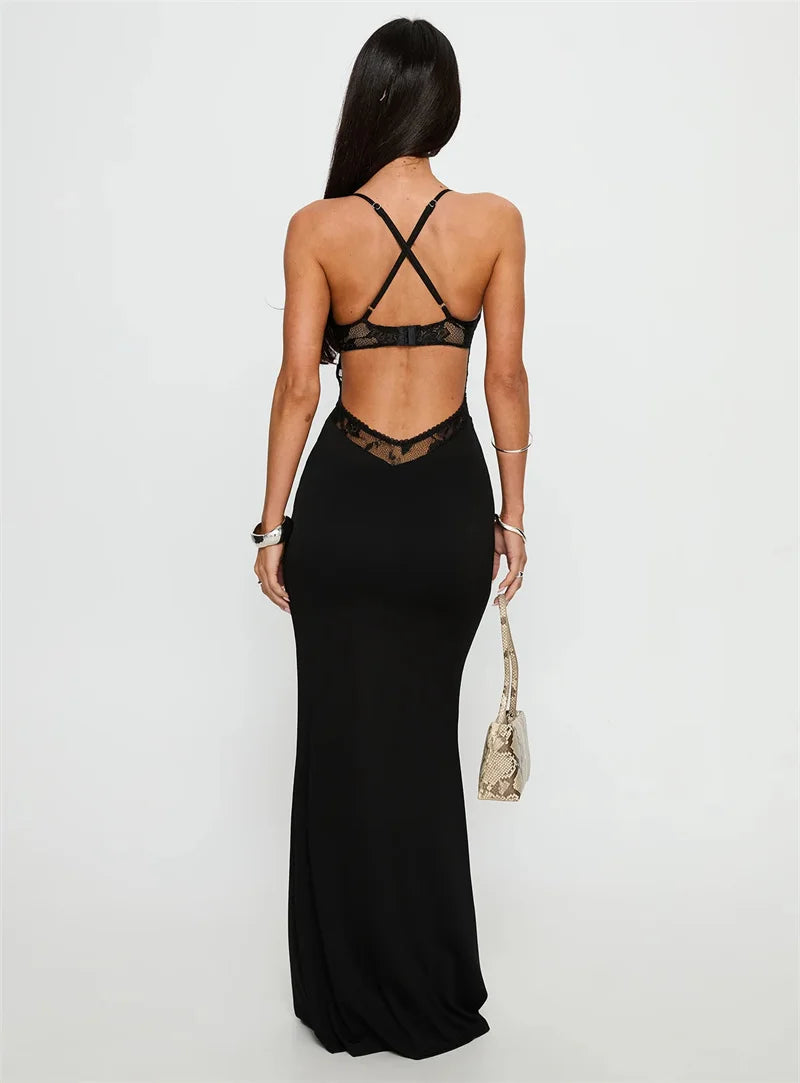 Woman wearing a black dress with sheer back panels on a white background