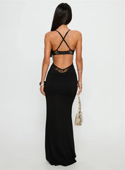 Woman wearing a black dress with sheer back panels on a white background