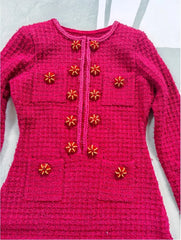 Pink knitted sweater with decorative buttons on a white background