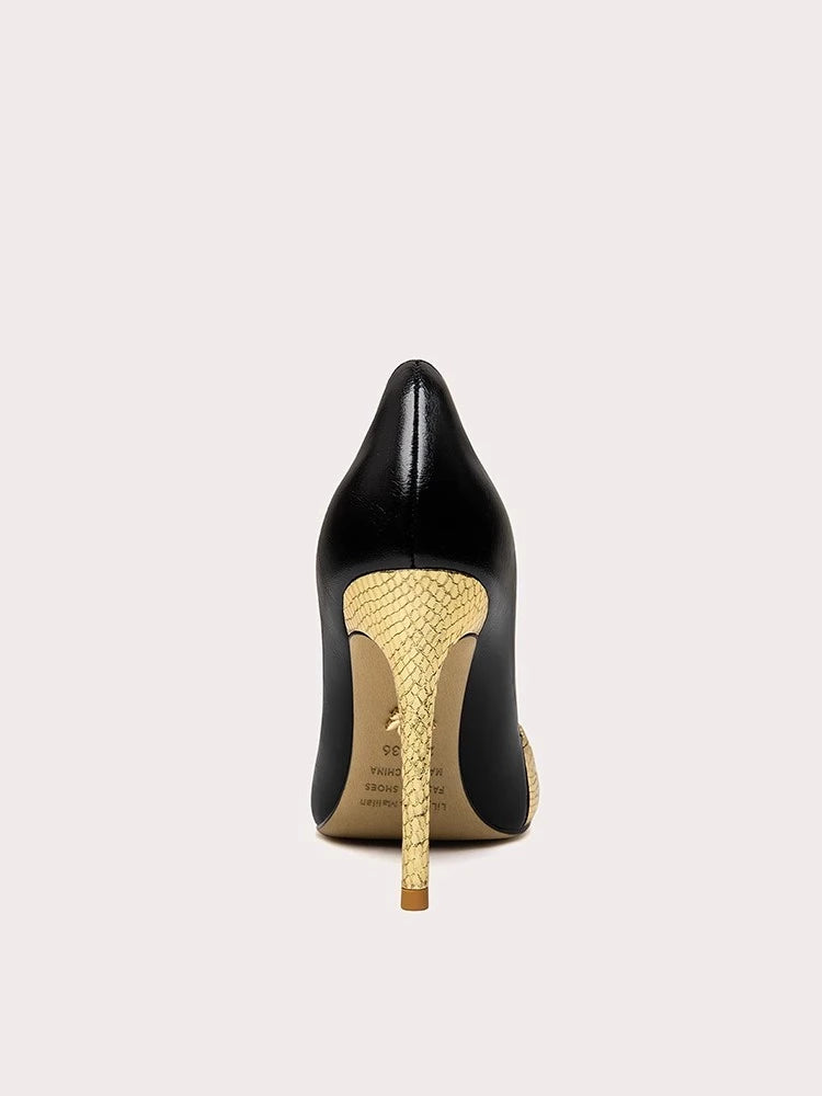 Black high-heeled shoe with gold snake skin pattern heel on a white background