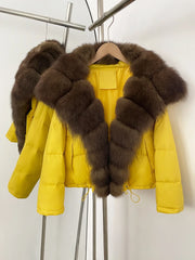 Yellow puffer jacket with brown fur collar on a rack against a white background