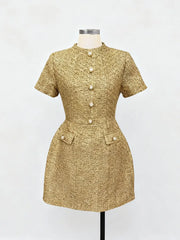 Gold textured dress on a mannequin against a white background