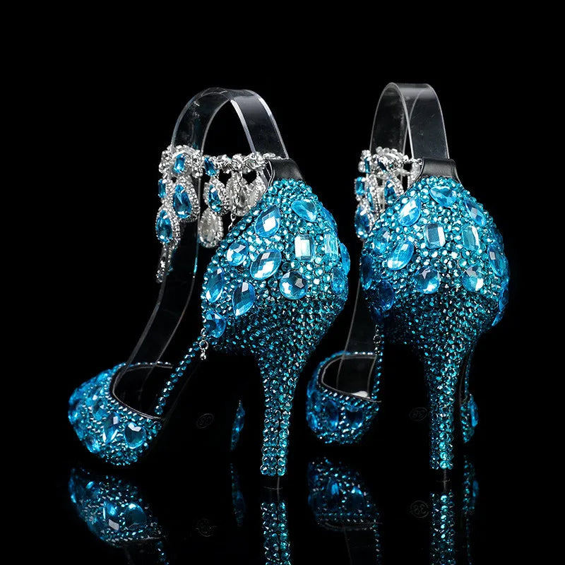 Blue high-heeled shoes with crystal embellishments on a black background