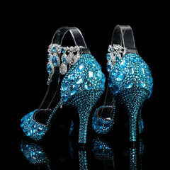 Blue high-heeled shoes with crystal embellishments on a black background