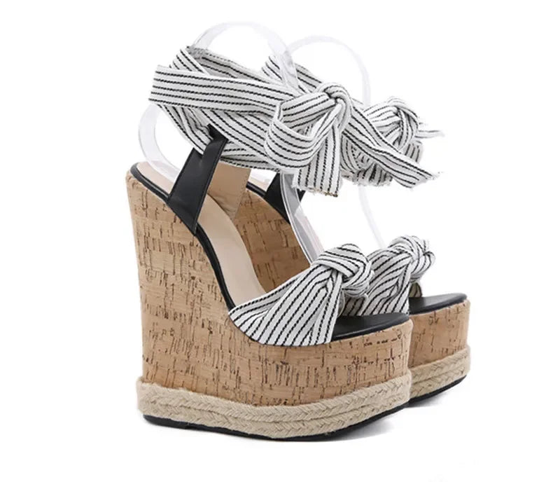Wedge sandals with cork platform and striped ankle straps on a white background