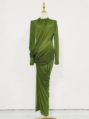Green draped dress on a mannequin against a white background