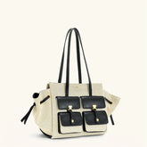 Beige handbag with black accents on a white background