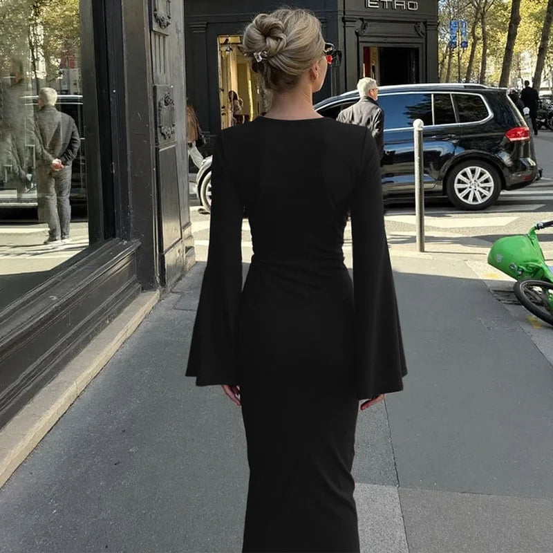 Woman in a black dress walking on a city street