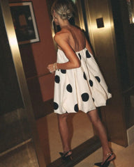 Woman in a polka dot dress standing in an elevator
