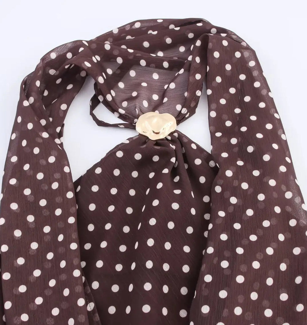 Brown polka dot scarf with a gold button on a white background