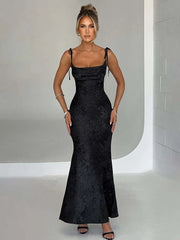 Woman wearing a black evening gown against a neutral background
