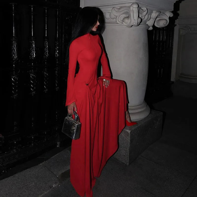 Person in a red dress standing next to a decorative column in an urban setting