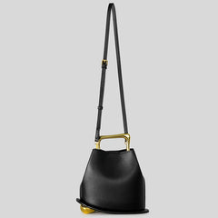Black handbag with gold accents on a light gray background