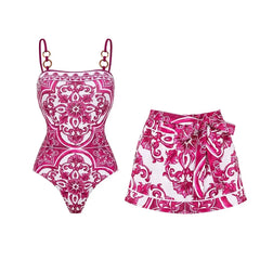 Pink and white floral print one-piece swimsuit and skirt set laid flat.