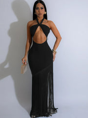 Woman wearing a black evening gown with a sheer overlay on a white background