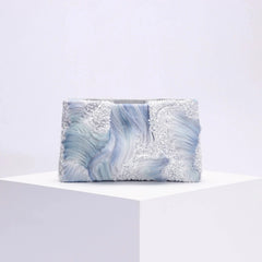 Clutch bag with blue and gray marbled pattern on a white background