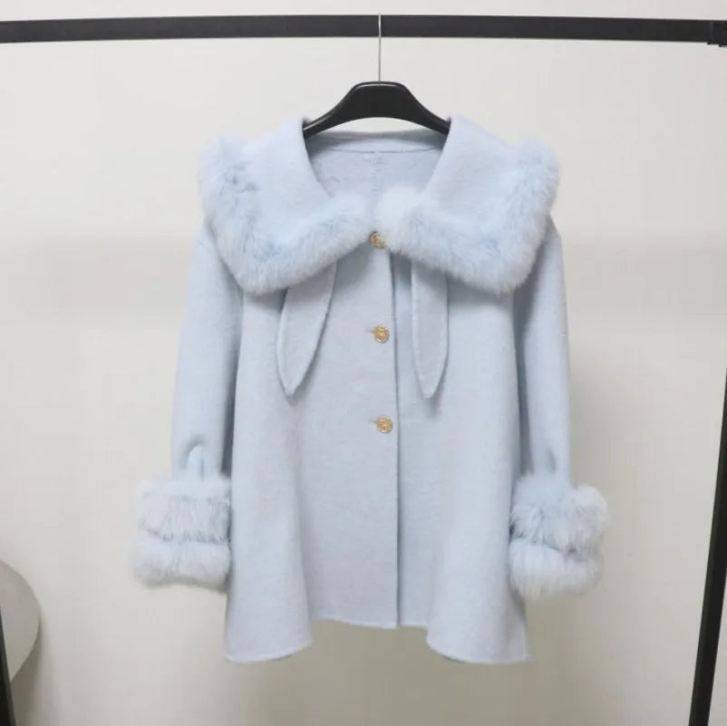 Light blue coat with fur trim on a hanger against a white background