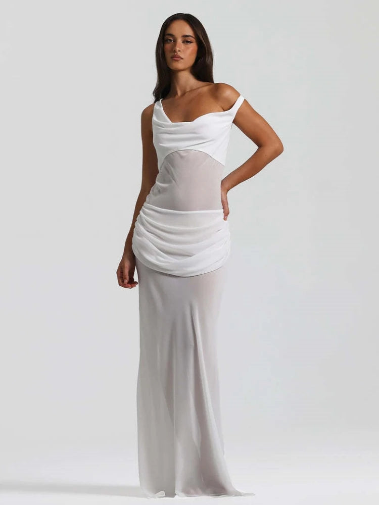 Woman wearing a white dress with sheer panels on a plain background