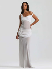 Woman wearing a white dress with sheer panels on a plain background