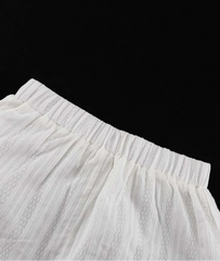 Close-up of a white skirt with a black background