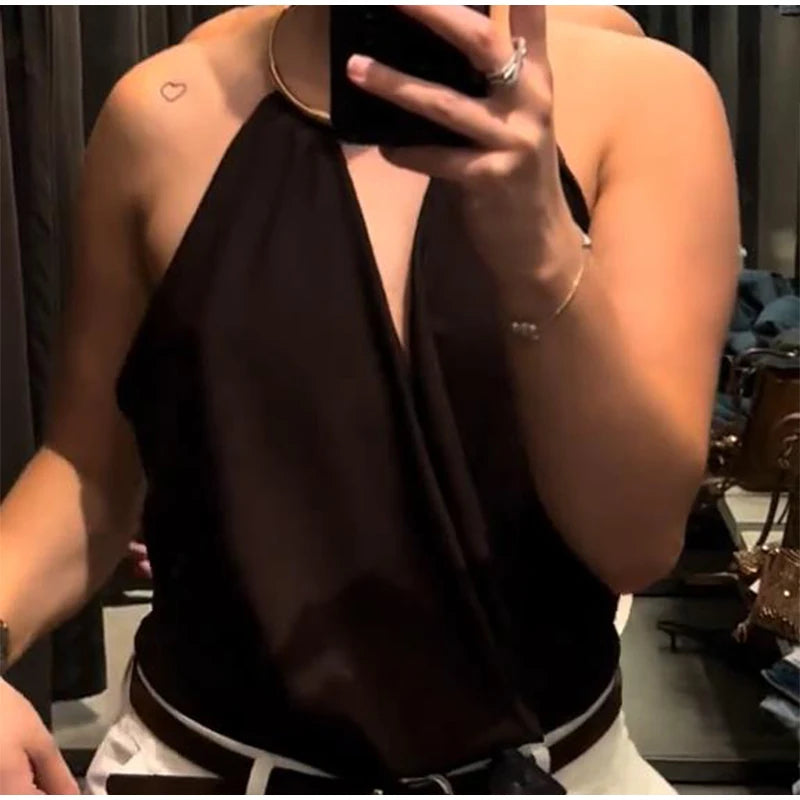 Person wearing a black halter top with a blurred background