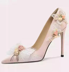 High-heeled shoe with floral decorations on a light pink background