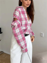 Person wearing a pink and white plaid shirt with cut-out sleeves in an indoor setting.