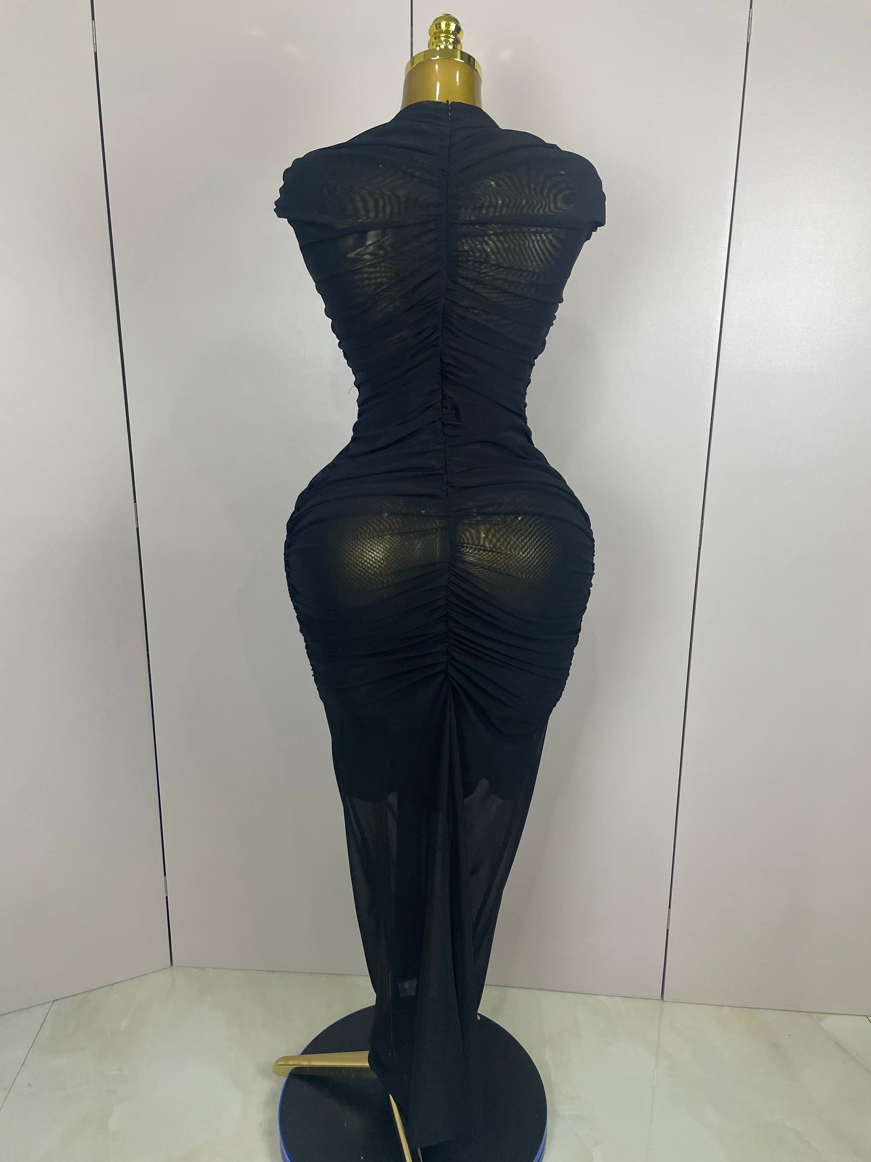 Black sheer dress on a mannequin against a white background