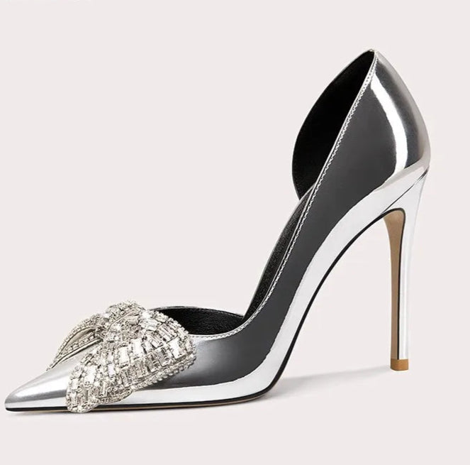 Silver high-heeled shoe with crystal embellishments on a light gray background