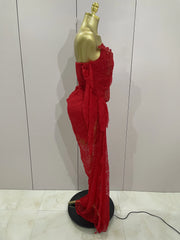Red lace dress on a gold mannequin against a white wall.