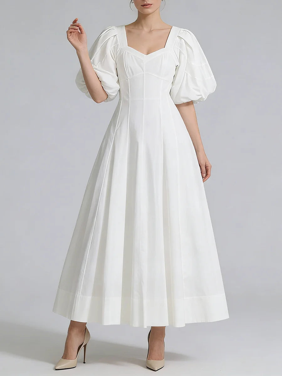 White dress with puff sleeves on a plain background