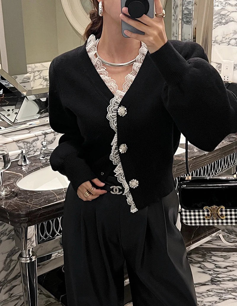 Person wearing a black outfit with white lace details in a bathroom setting.