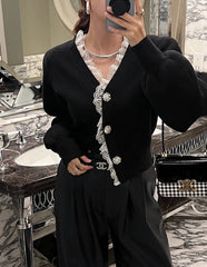 Person wearing a black outfit with white lace details in a bathroom setting.